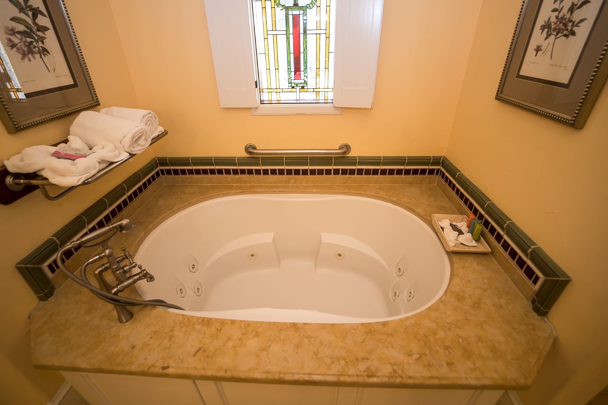Spa bathtub with pile of towels to the left and soaps in a dish to the right