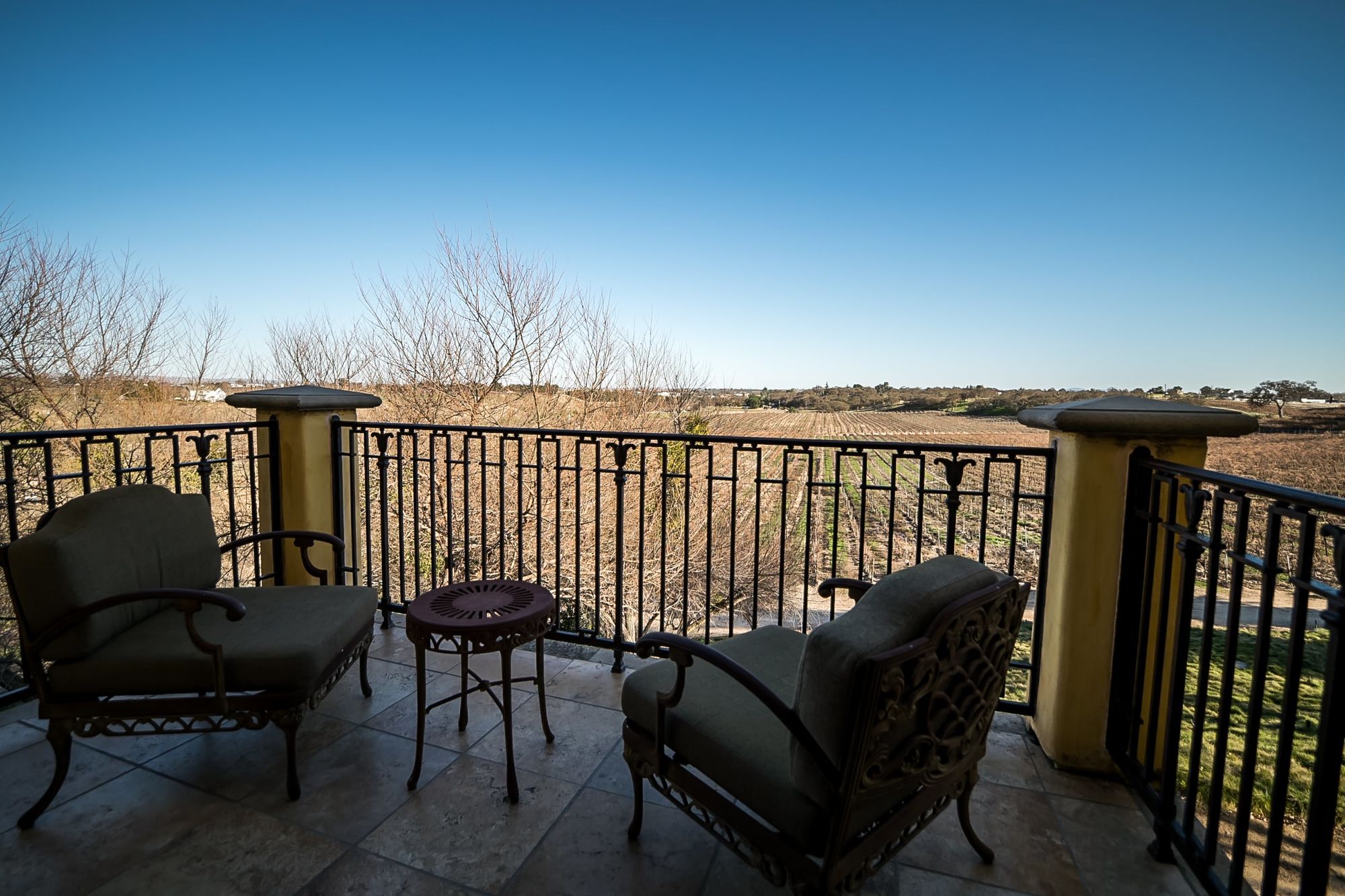 Patio with seating for two and view of the vineyard beyond