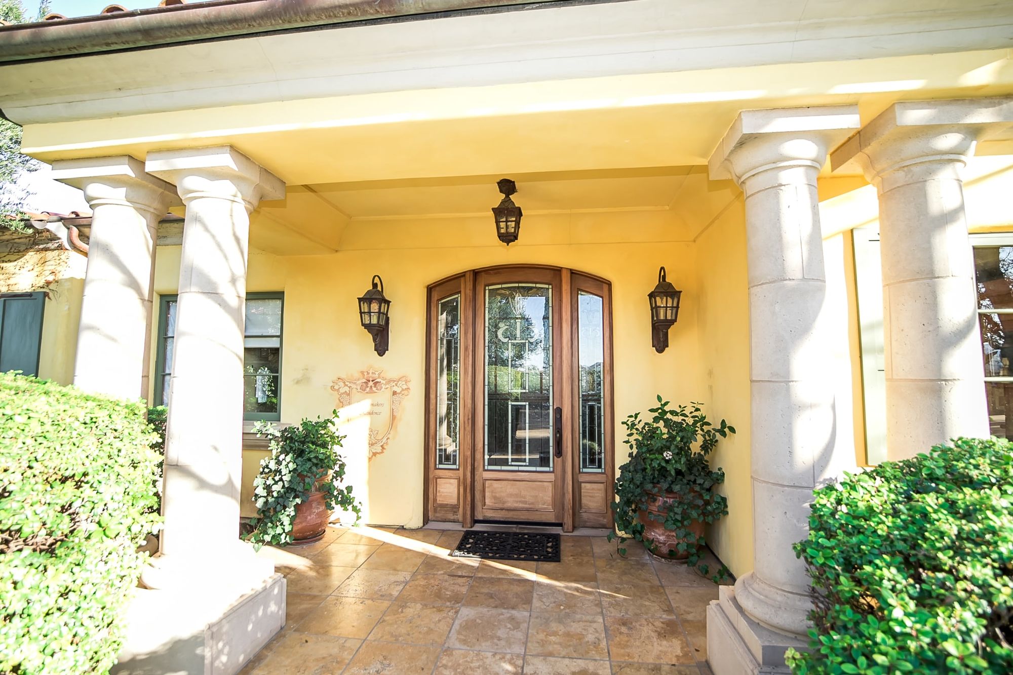 Front door with lighting and columns on either side